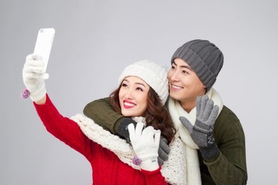 happy young hipster couple hugging. cold season. taking selfie photo