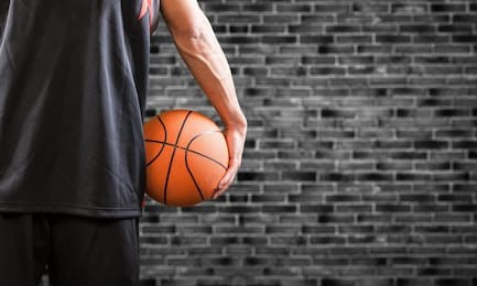 holding basketball on stone background