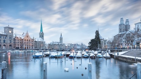 winter landscape of zurich with lake with boats on foreground, switzerland