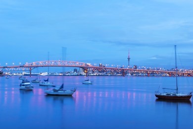 night view to the iconic harbour bridge auckland new zeland; light performance seeing from birkenhead wharf