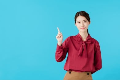 young asian woman pointing at copy space.