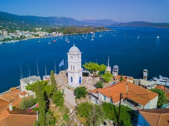 aerial drone bird's eye view photo of the clock tower of poros island, greece.