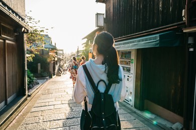 back view of beautiful lady walking on the street and in front her are two young girls walking with kimono. japanese lady with colorful traditional costume concept. asian travel alone in kyoto tour.