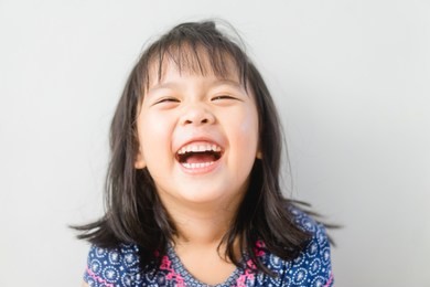 happy little asian girl child showing front teeth with big smile and laughing: healthy happy funny smiling face young adorable lovely female kid.joyful portrait of asian elementary school student.