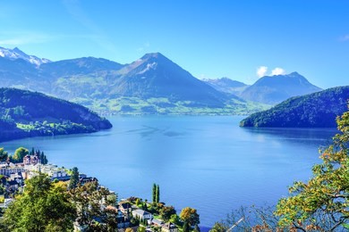 landscape photo of a view of the lake lucerne, the swiss alps and a part of the town of vitznau.