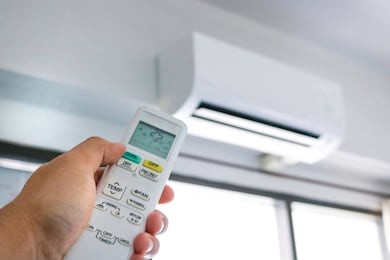 air conditioner control by remote on white wall in room