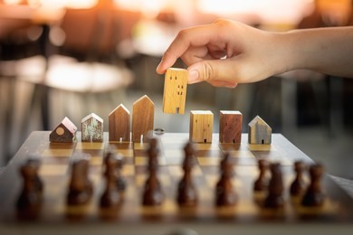 building and house models in chess game, business financial district and commercial , success and leadership business concept.