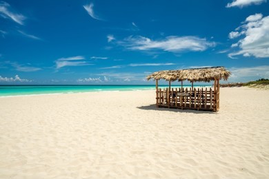 awesome beach of varadero during the day,in the middle a wooden and straw tent for massages on the beach, varadero cuba.