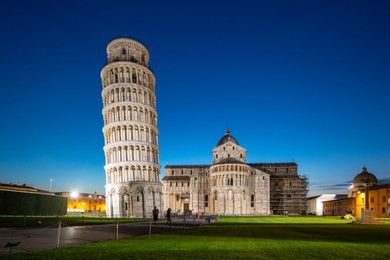 night view of pisa cathedral with leaning tower of pisa on piazza dei miracoli in pisa, tuscany, italy. the leaning tower of pisa is one of the main landmark of italy