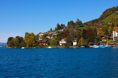 interlaken a narrow stretch of valley, between the emerald-colored waters of lake thun and lake brienz, it has old timber houses and parkland on either side of the aare river surrounded by mountains