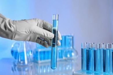 scientist holding test tube with liquid for analysis in laboratory