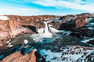 woman at aldeyjarfoss, iceland. tourist at famous waterfall in iceland.