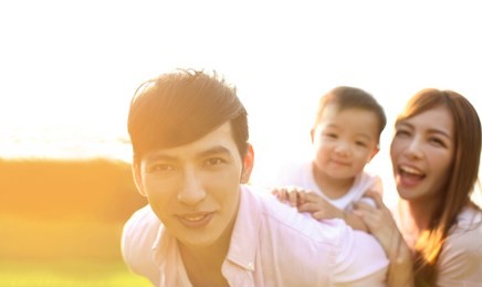 young family with baby having fun in nature