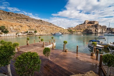 st. paul bay with boats, lindos acropolis in background (rhodes, greece)