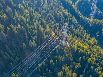 aerial view of power line pylon in mountaineous area in switzerland