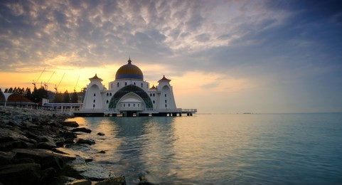 straits mosque of malacca, malaysia during sunrise. the mosque is located on the reclaimed land at malacca island, malaysia.