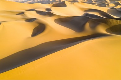 aerial view of desert landscape in sunset, golden sand dunes background texture