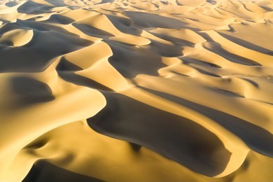 aerial view of desert landscape in sunset, golden sand dunes background texture