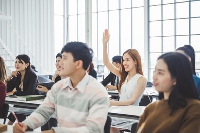 business woman raising hand for asking speaker for question and answer concept in meeting room for seminar