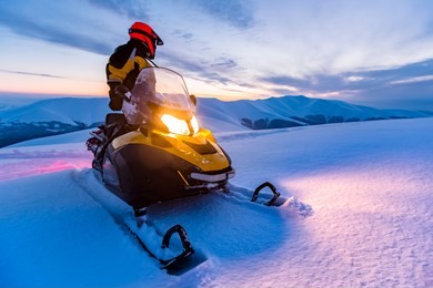 a rider on the snowmobile. beautiful winter day in ukrainian mountains. sunset.