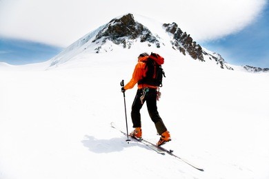 lone alpine touring skier on the big verra glacier; in background the peaks of castore and polluce. monterosa, swiss-italy border.