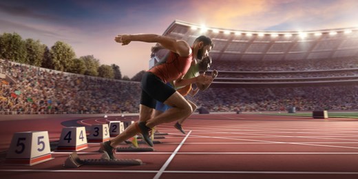 male athletes sprinting. two men in sport clothes run at the running track in professional stadium