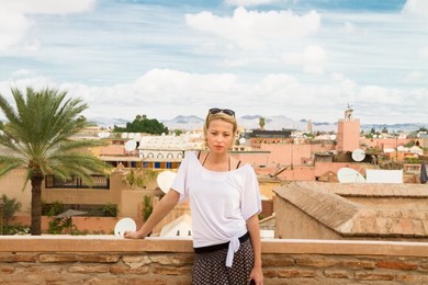 female traveler admiring traditional moroccan architecture in one of the palaces in medina of marrakesh, morocco.