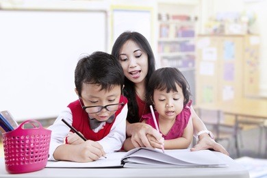 teacher and children study in classroom together