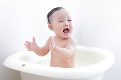 cute baby girl applaud while taking bath at home