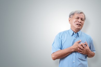 older asian man clutching and having chest pain cause from heart attack. heart disease in senior man with isolated background and have clipping path. old people healthcare insurance concept.