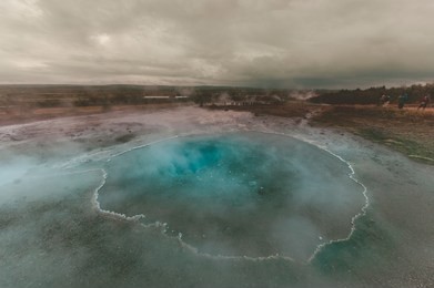 strokkur (churn) fountain geyser in the geothermal area beside the hvítá river. haukadalur, geysir - iceland