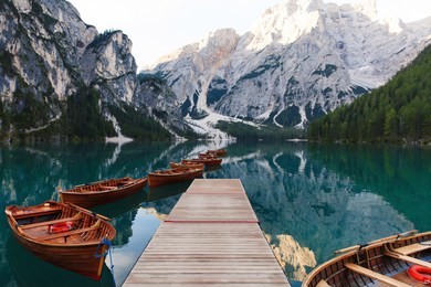 beautiful landscape of braies lake (lago di braies), romantic place with wooden bridge and boats on the alpine lake, alps mountains, dolomites, italy, europe