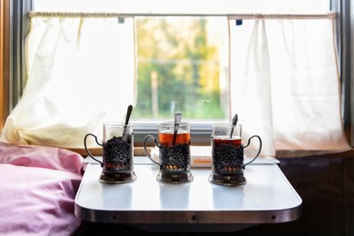 glasses, cups of tea on the table in the train