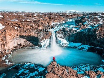 man at aldeyjarfoss, iceland. tourist at famous waterfall in iceland.