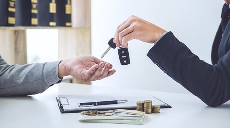 salesman send key to customer after good deal agreement, successful car loan contract buying or selling new vehicle.