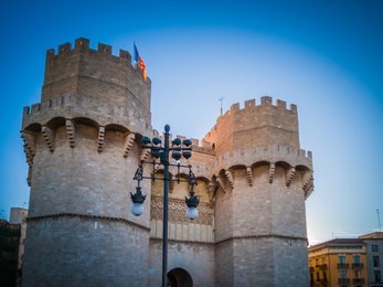 a photo of the exterior facade of the popular torres de serranos, which was one of the gates of the ancient of the city wall, christian wall, of valencia, in spain, europe. the photo was taken at dusk