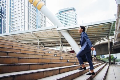new gen young businessmen are stepping up their stairs to get in business with confidence in bangkok, thailand.