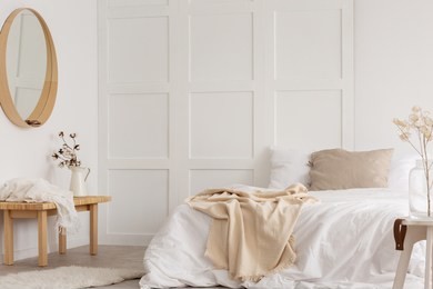 white simple bedroom design with mirror, dresser and comfortable bed with white sheets, real photo