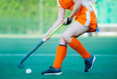 young hockey player woman with ball in attack playing field hockey game