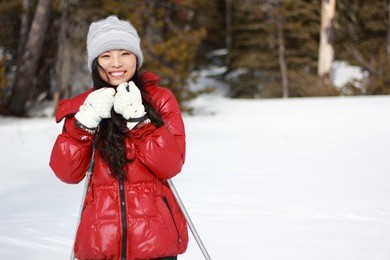 a happy young woman in red in the snow