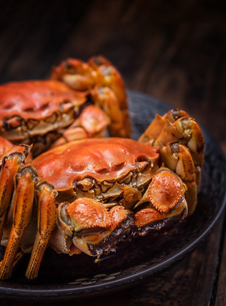 two cooked hairy crabs on the table.	