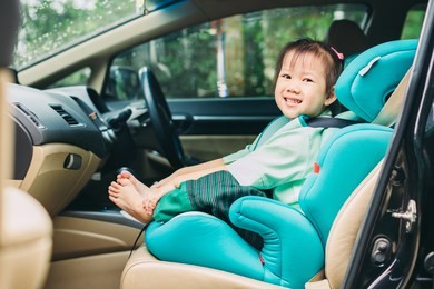 kid wait for mother and sit in the car seat for safety before go to school.