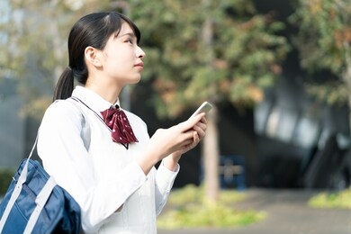 asian school girl using a smart phone.