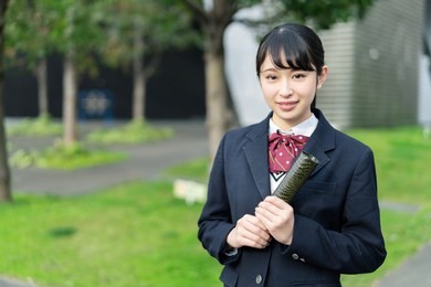 asian school girl holding a diploma.