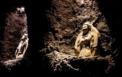 ancient buddhist iconography and statues in cave alcove at jiaohe ruins in turpan, xinjiang, china.