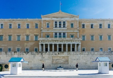 evzones or evzonoi guarding the tomb of the unknown soldier at the hellenic parliament building (the old royal palace) on syntagma square in athens, greece, 2018