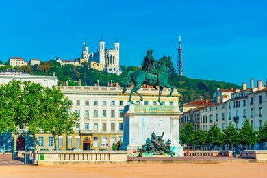 basilica notre-dame de fourviere viewed behind statue of louis xiv in lyon, france