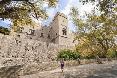 girl admires grand master palace in city of rhodes (rhodes, greece)