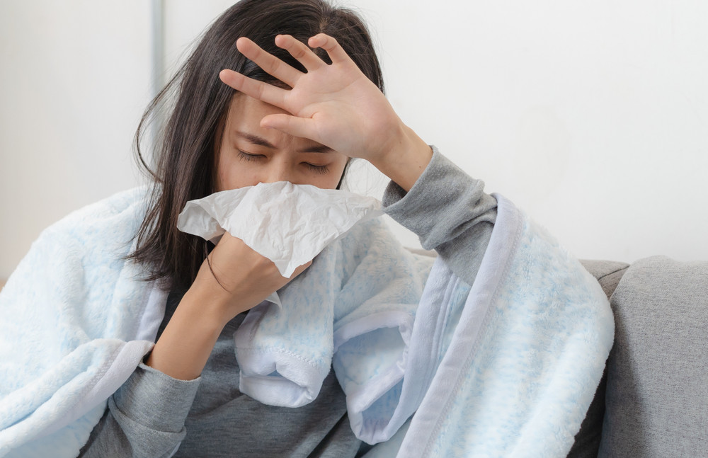 sick day at home. asian woman has runny and common cold.