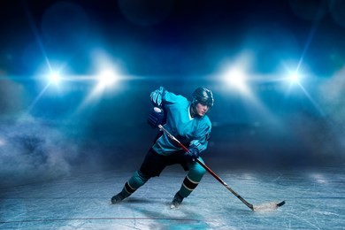 one hockey player on ice, spotlights on background